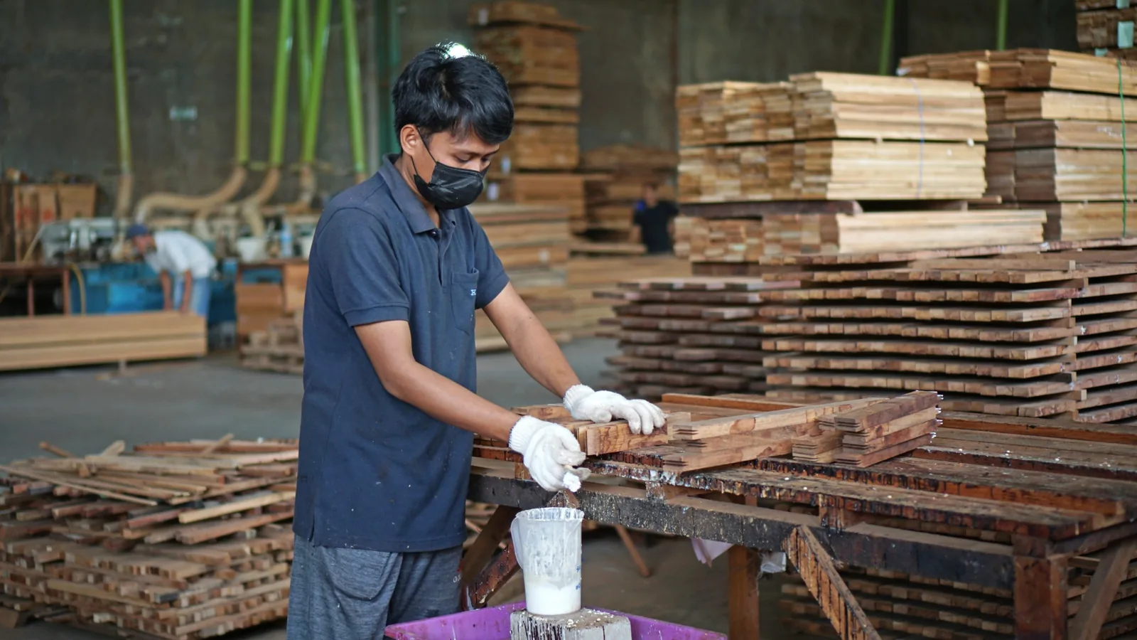 A skilled maker assembling wooden components by hand inside the workshop